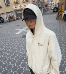 a person wearing a white hoodie that says ticket on the front