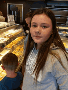 a girl in a the north face sweatshirt stands in front of a display case