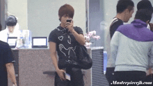 a man in a black shirt with hearts on it is talking on his phone