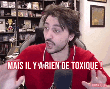 a man sitting in front of a microphone with the words mais il y a rien de toxique below him