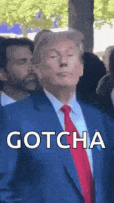 a man in a suit and tie is standing in front of a crowd and says `` gotcha '' .