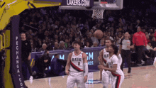 a basketball game is being played in front of a lakers.com sign