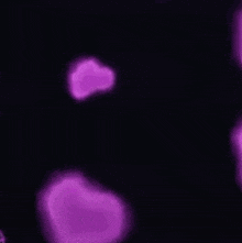 a person is standing in front of a bunch of pink hearts .