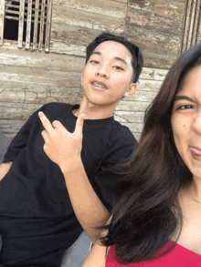 a boy with braces on his teeth is giving the middle finger to a girl