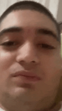 a close up of a man 's face with his eyes closed and a shaved head .