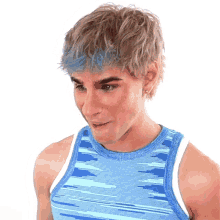 a young man with blue hair is wearing a blue and white tank top