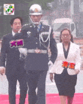 a man in a military uniform is walking with a woman in a white jacket