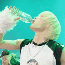 a young man drinking water from a bottle
