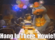 a picture of a chuck e cheese mascot with the caption hang in there howie