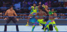 a group of wrestlers are fighting in a wrestling ring with a crowd watching ..