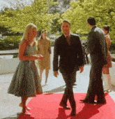 a group of people standing on a red carpet