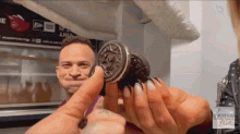 a man and a woman are holding an oreo cookie with laura allie written on the bottom
