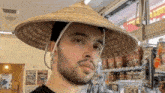 a man with a beard wearing a straw hat in a store