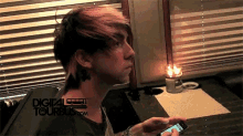 a young man looking at a cell phone with a digital tourbus.com logo in the background