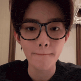 a close up of a person wearing glasses and making a funny face