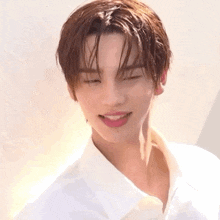 a close up of a young man wearing a white shirt with his eyes closed and his tongue sticking out .