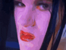 a close up of a woman 's face with red lips and a purple background