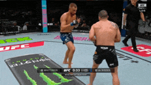 two men are fighting in a ufc ring with a monster energy drink in the background