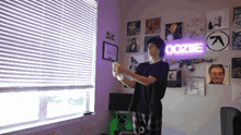 a man stands in front of a room with a sign that says ooziie