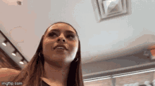 a woman is looking up at the camera with a red exit sign in the background ..