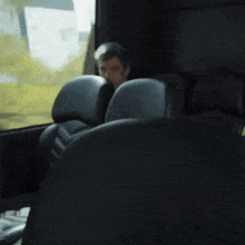 a man is sitting in a bus looking out the window