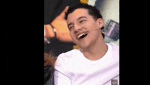 a young man with a microphone in his mouth is smiling .