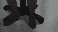 a person 's feet are standing on a black office chair
