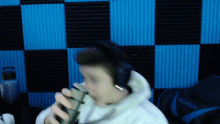 a person wearing headphones and holding a microphone in front of a wall that says spawn on it