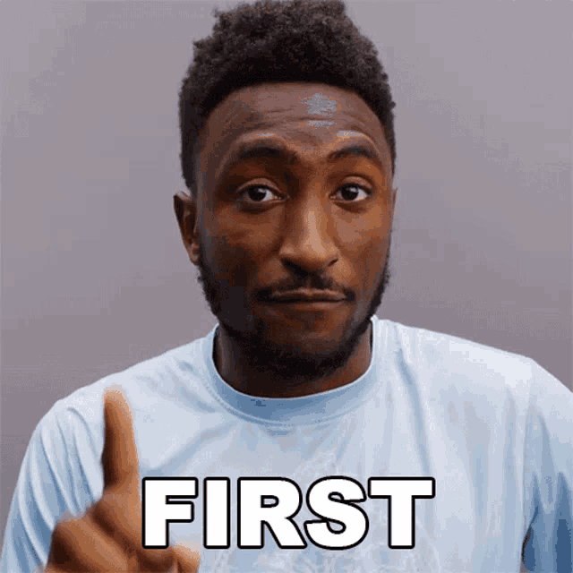 a man giving a thumbs up with the word first written on his shirt
