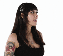 a woman with a tattoo of monkey d luffy on her arm is wearing a black top