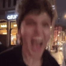a blurry picture of a man with his mouth open in front of a sign that says ' o'ruc ' on it