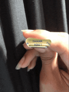 a woman holds a thank you sticker in her hand