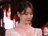 a woman wearing a white dress and a necklace with the word gucci on the bottom right