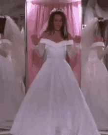 a woman in a wedding dress is dancing in a room .