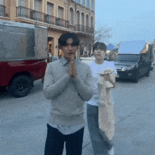 a man in a grey sweater is standing next to another man