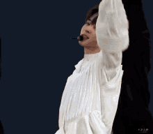 a man with a microphone in his mouth is wearing a white shirt and black jacket