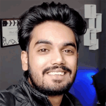 a man with a beard is smiling for a picture