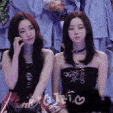 two girls are sitting next to each other with the word g on the right
