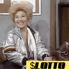 a woman in a silver jacket is smiling in front of a sign that says lotto