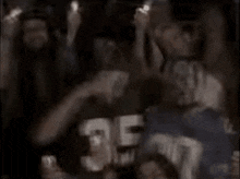 a group of people are standing in a dark room holding candles in their hands .