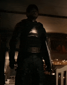 a man in a superhero costume holds a shield