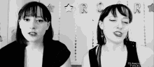 two women are singing in front of balloons that say r