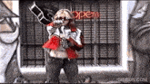 a woman is holding a guitar in front of an open sign ..