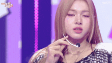 a woman wearing a microphone on a stage with the kbs logo in the corner