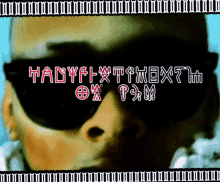 a picture of a man wearing sunglasses with the words tadyflxtthextm written on it