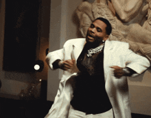 a man in a black shirt and white jacket is dancing