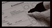 a person is using a marker to fill out a ballot that says erststimme