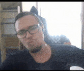 a man with glasses and a beard is making a face