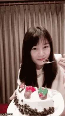 a girl is eating a cake with a spoon .
