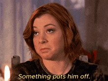 a woman says something puts him off while sitting in front of a candle